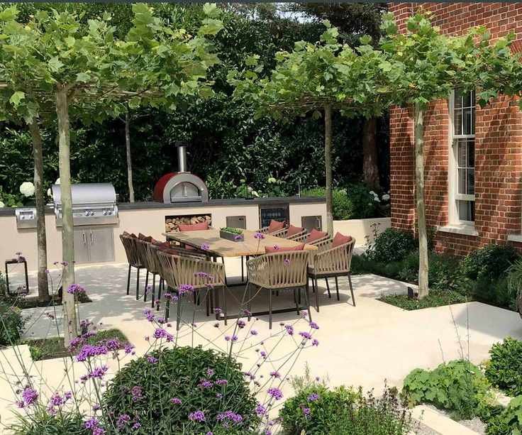 Outdoor kitchen with dining area and trees as a canopy