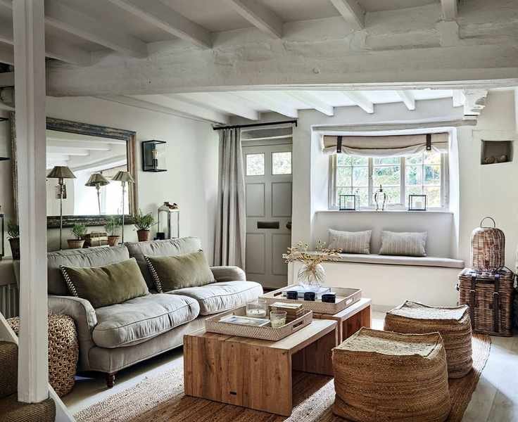 Cozy living room with a neutral color palette, window bench seating, wooden coffee tables, and textured low seats