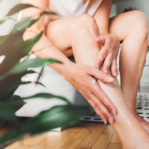 Applying body lotion to legs after a day at the beach Applying body lotion to legs after a day at the beach