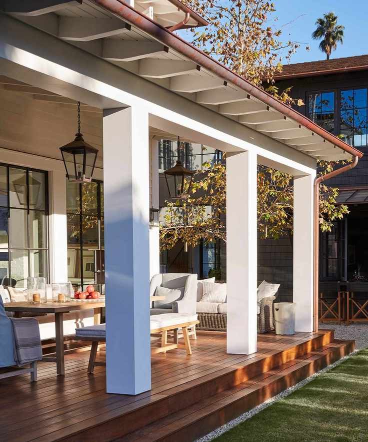 Front porch ideas for dining showing a wooden table on a wooden deck in the sun