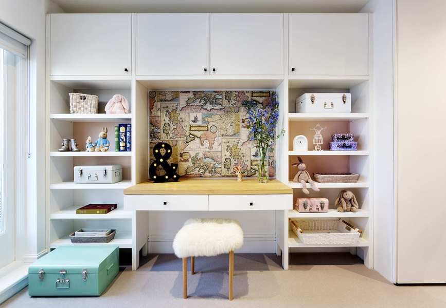 teen girl bedroom with dressing table and built in storage, wide drawers, cupboards above, turquoise trunk, sheepskin covered stool