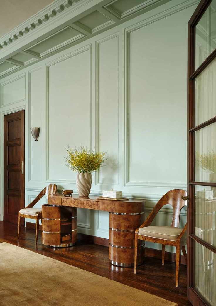 a burl wood credenza with a vase of flowers on it and two chairs on either side