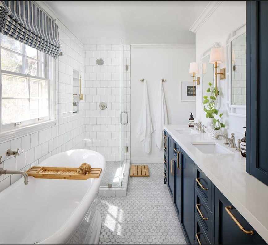 A bathroom featuring a roll-top bath and blue cabinets