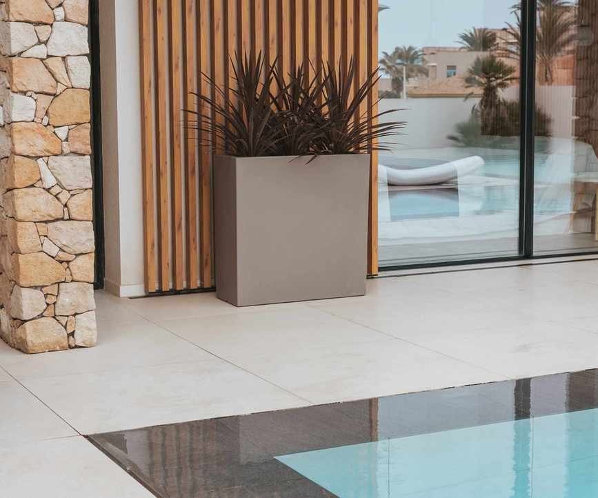Junco planter with succulents near a pool