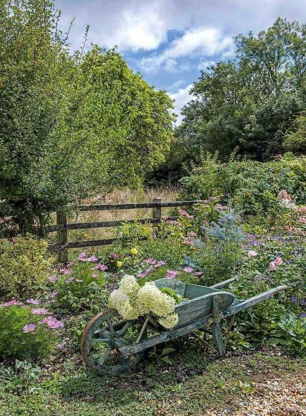Post and rail fence with wheelbarrow