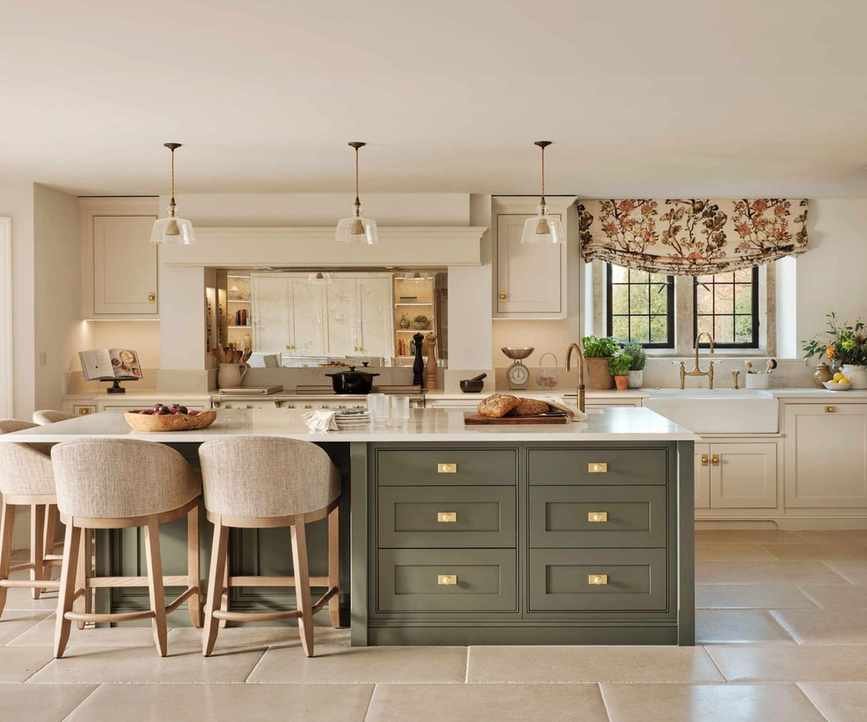 A midimalist kitchen featuring white cabinets and a green island