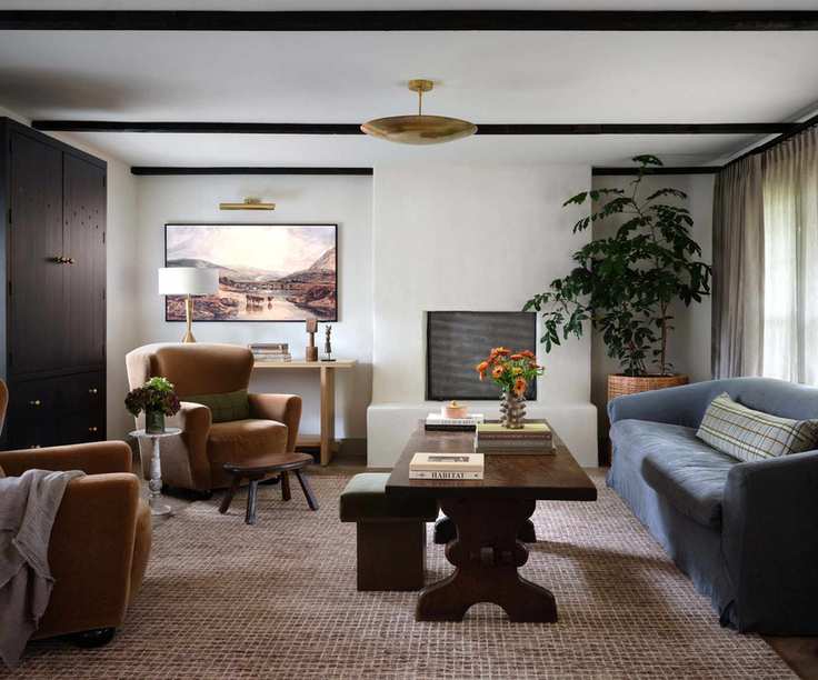 Living room with built in storage cabinet, white walls and ceiling beams