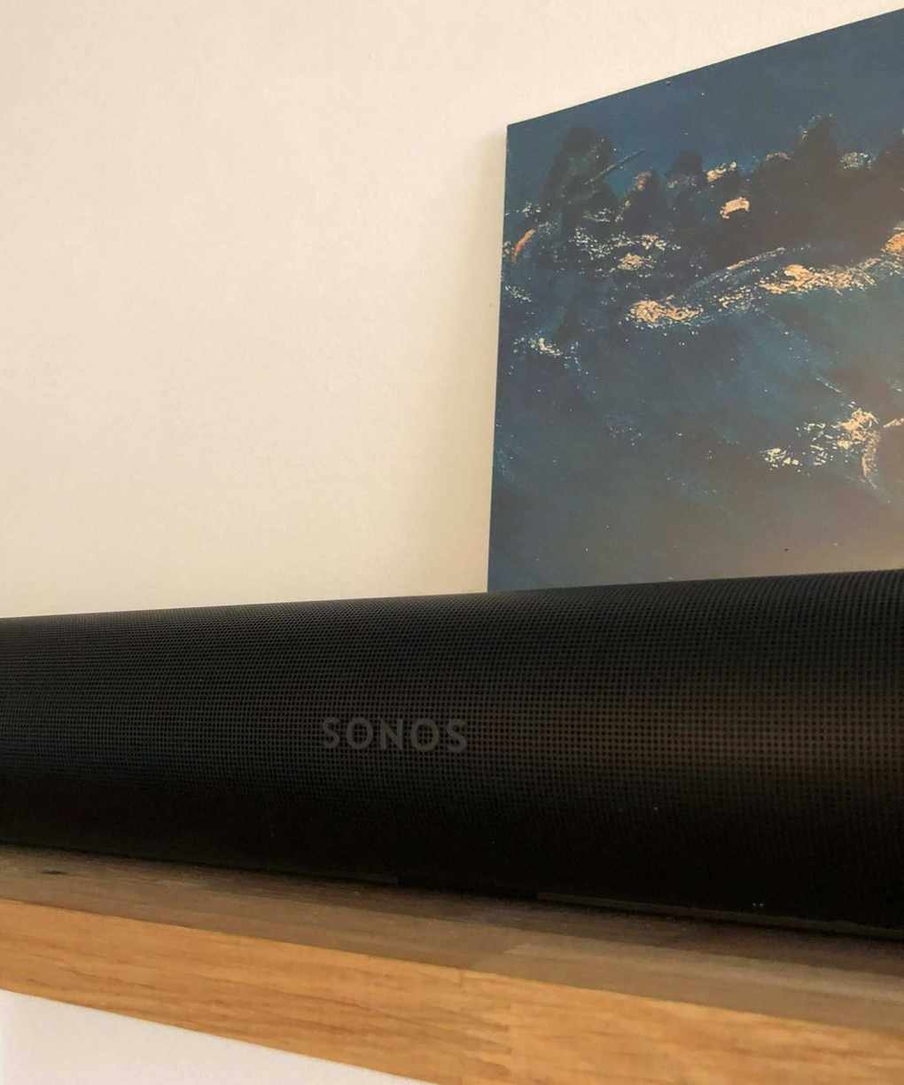 Sonos Arc Ultra soundbar on wooden shelf in front of vinyl sleeve of The Avalanches' Since I Left You.