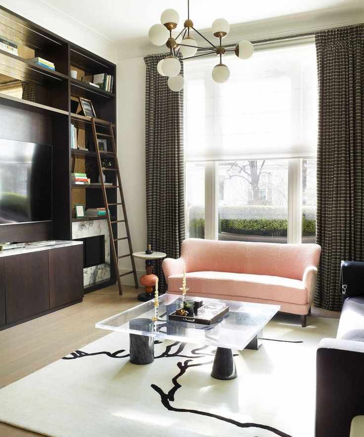 Living room with brown storage units, wooden ladder, marble fireplace, black and cream rug, glass coffee table, and colorful side tables