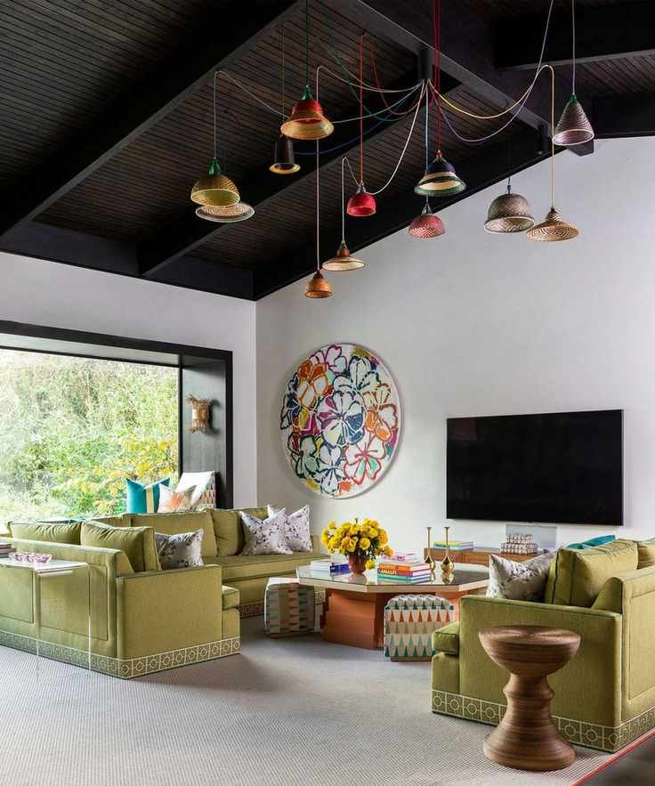 Modern living room with a striking pendant light display under a dark vaulted ceiling