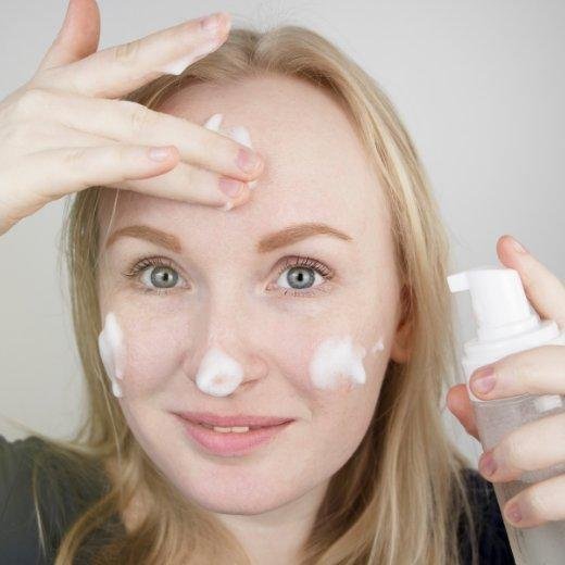 Woman using a gentle foaming cleanser on skin prone to redness and rosacea Woman using a gentle foaming cleanser on skin prone to redness and rosacea