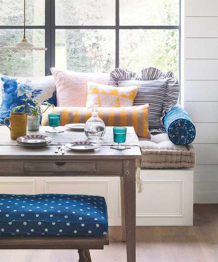 Dining room with window seat and colored glassware