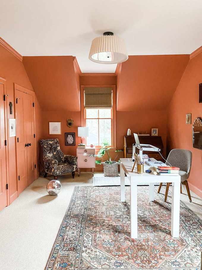 Orange home office with textured rug and armchair