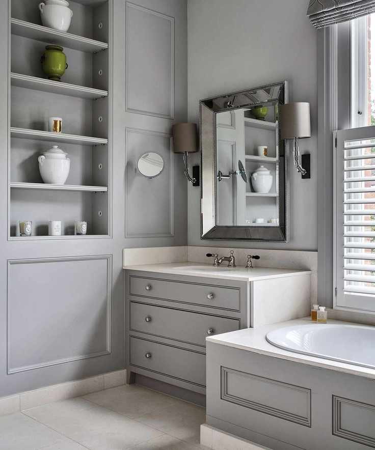 An example of bathroom storage ideas showing a gray bathroom with fitted storage shelves and a mirror on the wall