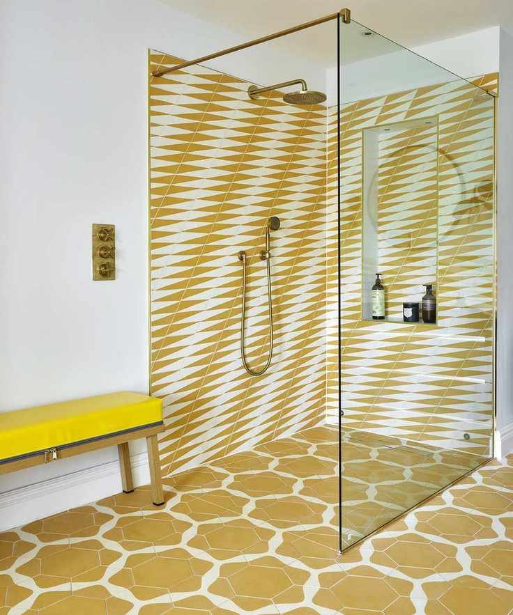 A yellow tiled shower room featuring a glass screen