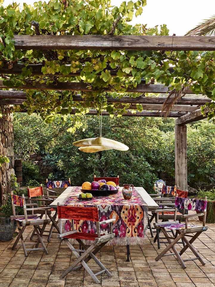 Boho-style patio furniture under a rustic pergola.