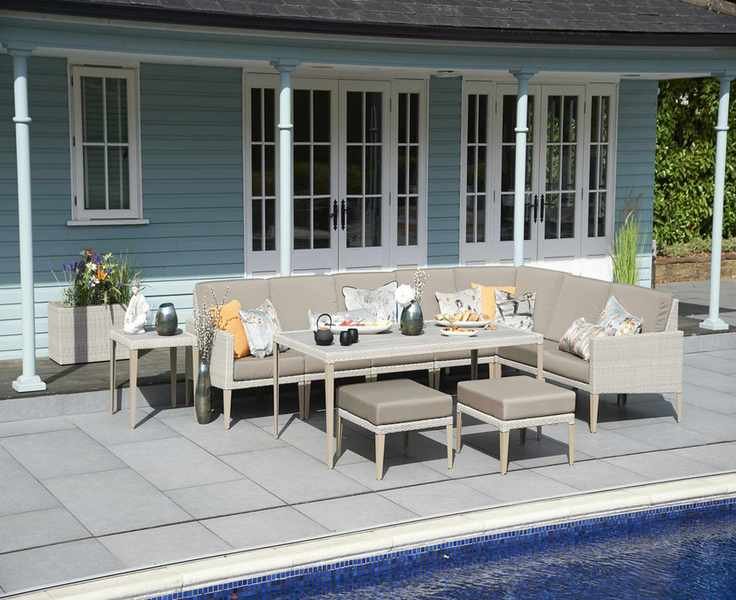 A sectional sofa between a blue house and pool.