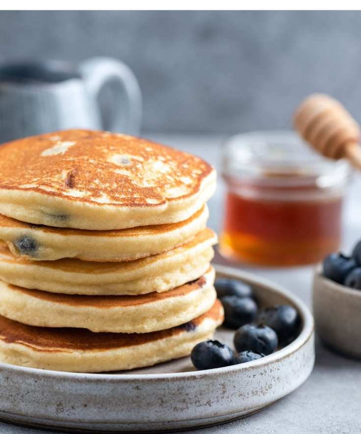 Fluffy pancakes topped with blueberries in a serving dish