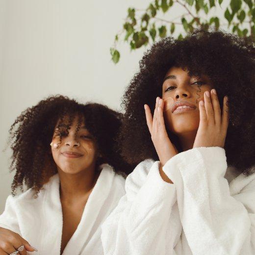 Two women with skin care masks doing at home skin care routine
