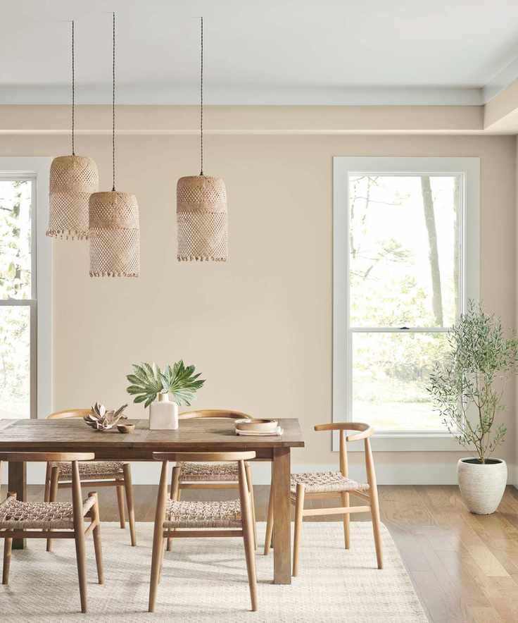 dining room with beige walls, wooden dining table and chairs and houseplants