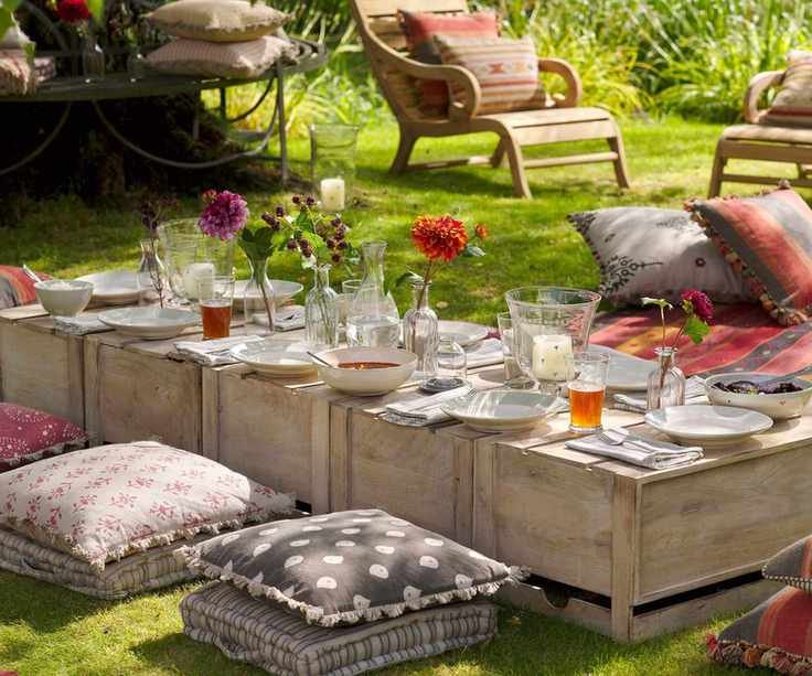 Garden picnic with wooden crates as tables and floor cushions by Susie Watson designs