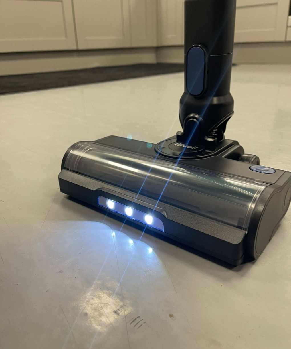Levoit LVAC-300 cordless vacuum cleaner floorhead, with LED lights illuminating the linoleum floor in testing center.