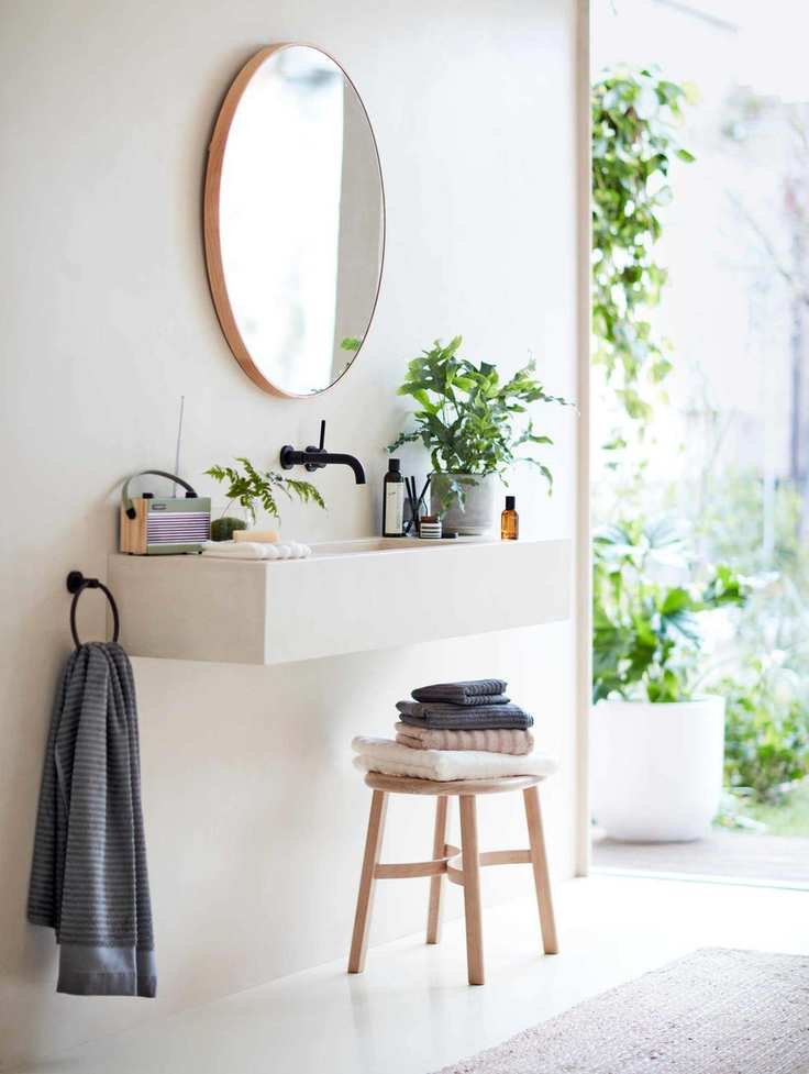 A wall-hung vanity unit with a mirror and a stool underneath