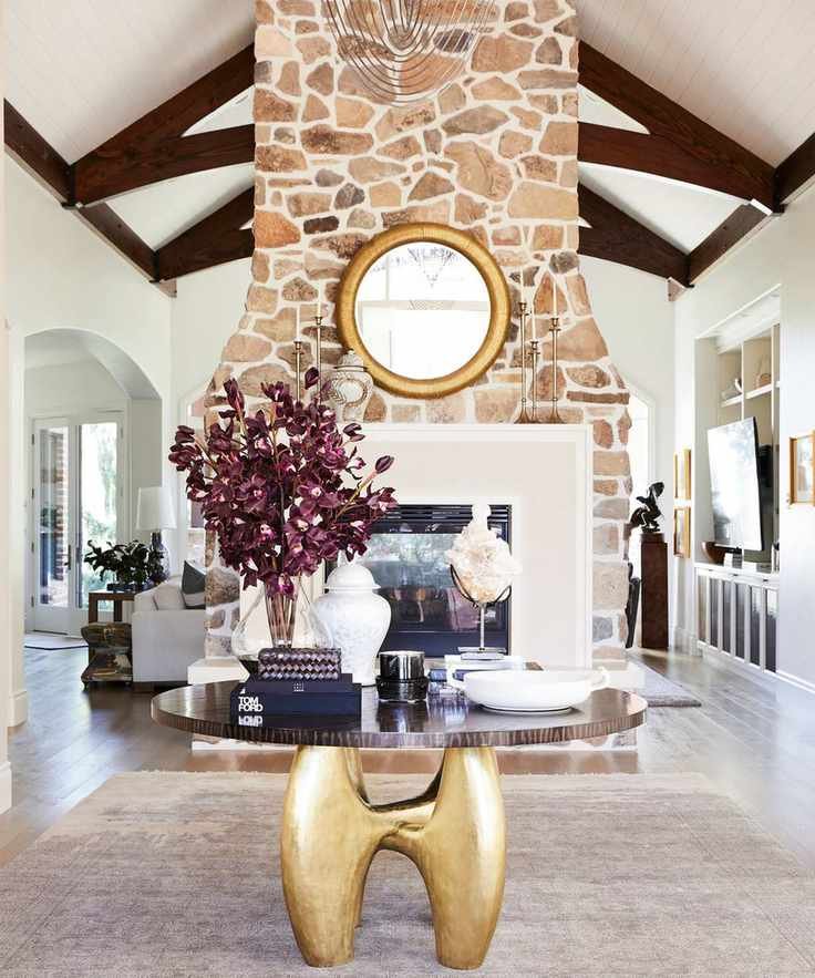 Large living room with vaulted ceiling and a feature stone fireplace, complemented by a modern design