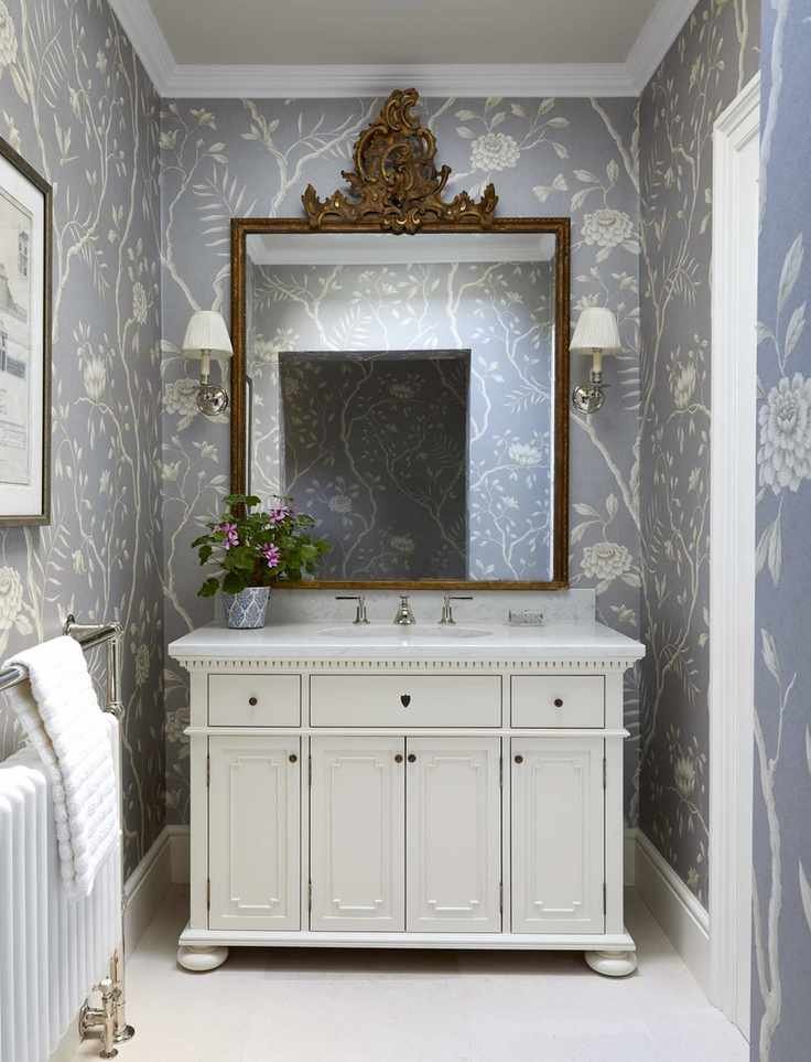 Blue rose pattern wallpaper, white cabinet with sink and bronze mirror