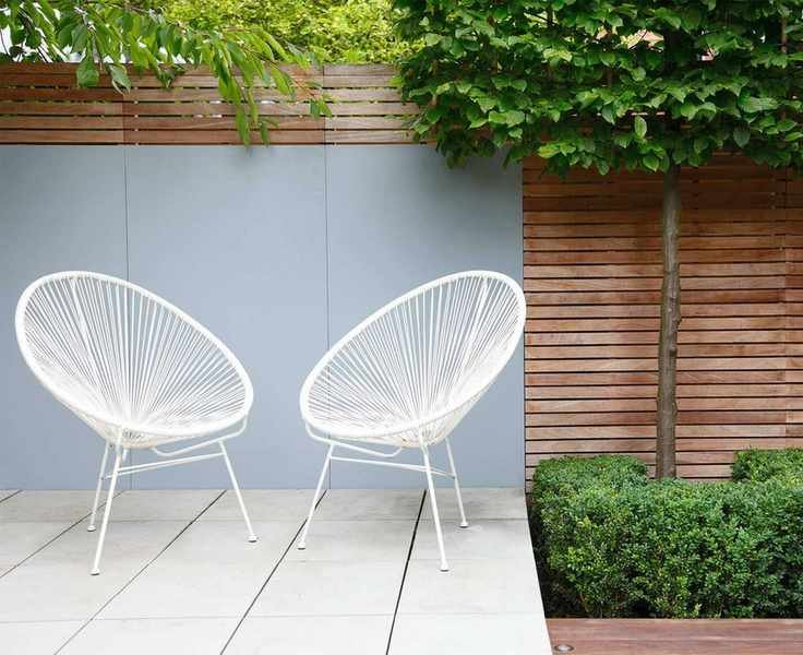 Slim white chairs exemplifying a small garden setup.