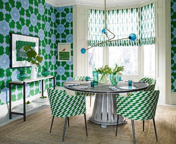 Colorful dining area with blue and green floral wallpaper and a dark wood table.